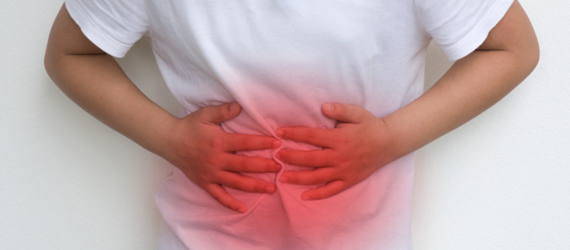 Woman Child's hands on her stomach with red spot as suffering on stomachache. Girl school kid suffer from Chronic Diarrhea,Digestive Disorders, stomach pain,Crohnâs Disease, irritable bowel syndrome